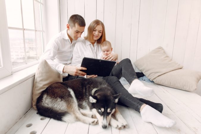 Couple sitting with baby in arms and dog lying at feet